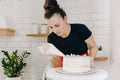 Chef or baker decorating cake with white whipped cream. Royalty Free Stock Photo