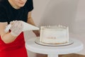 Chef or baker decorating cake with white whipped cream. Royalty Free Stock Photo