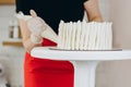 Chef or baker decorating cake with white whipped cream. Royalty Free Stock Photo