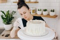 Chef or baker decorating cake with white whipped cream. Royalty Free Stock Photo