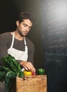 Chef, basket and business owner with vegetables or groceries in a bag for cooking or diet in kitchen. Man packing Royalty Free Stock Photo