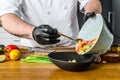 A chef in black gloves prepares a vegatarian vegetable salad. Concept of cooking healthy organic food Royalty Free Stock Photo