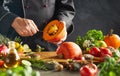 Chef in black scooping seeds out of small pumpkin Royalty Free Stock Photo