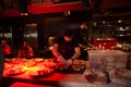 The chef in a black uniform decorates the food on the plates