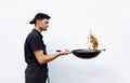 Chef in black uniform holding a frying pan with fried noodle Royalty Free Stock Photo