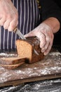 chef in black uniform holds a kitchen knife in his hand and cuts off pieces of bread Royalty Free Stock Photo