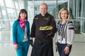 Chef in black uniform poses with plate of snacks and beautiful women in Lviv airport hall