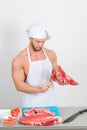 Chef bodybuilder preparing large chunks of raw