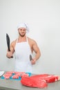 Chef bodybuilder preparing large chunks of raw