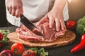 Chef Butcher cutting pork meat with knife on kitchen, cooking food. Royalty Free Stock Photo