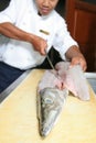 Chef butchering barracuda fish