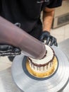 chef cake decorator squeezing a bottle containing chocolate ganache on a cake Royalty Free Stock Photo