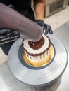 chef cake decorator squeezing a bottle containing chocolate ganache on a cake Royalty Free Stock Photo