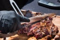 Chef carving a portion of grilled rib eye meat