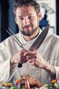 Chef. Chef funny. Chef with knife and fork arms crossed. Professional chef in a restaurant or hotel prepares or cut up T-bone Royalty Free Stock Photo