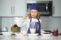 Chef child cooking healthy meal and dinner preparation. Funny little kid chef cook wearing uniform cook cap and apron Royalty Free Stock Photo