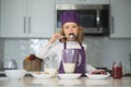Chef child cooking healthy meal and dinner preparation. Kids are preparing the dough, bake cookies in the kitchen, lick Royalty Free Stock Photo