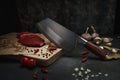 Chef chopping knife with a piece of meat and vegetables, preparation in the kitchen of spicy food with red pepper. Royalty Free Stock Photo