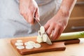 Chef chopping leek in kitchen