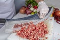 Chef is chopping the raw beef on cutting board with knife to cook in the kitchen, minced beef. Kebab restaurant, kebab preparation