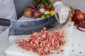 Chef is chopping the raw beef on cutting board with knife to cook in the kitchen, minced beef. Kebab restaurant, kebab preparation