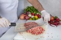 Chef is chopping the raw beef on cutting board with knife to cook in the kitchen, minced beef. Kebab restaurant, kebab preparation