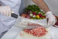 Chef is chopping the raw beef on cutting board with knife to cook in the kitchen, minced beef. Kebab restaurant, kebab preparation