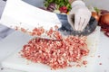 Chef is chopping the raw beef on cutting board with knife to cook in the kitchen, minced beef. Kebab restaurant, kebab preparation