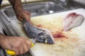 Chef cleaning sea bream in the kitchen. A Chef in a cuts up fish. Still life on the kitchen Board. Hearty food for cold regions Royalty Free Stock Photo