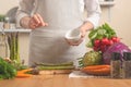 The chef cleans asparagus, with vegetables on a light background. The concept is loss of healthy and healthy food, detox, vegetry