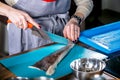 Chef cleans fish from scales. Master class in the kitchen. The process of cooking. Step by step. Tutorial. Close-up Royalty Free Stock Photo