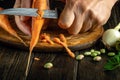 The chef cleans fresh carrots with a knife for cooking vegetarian food. The concept of cooking vegetable diet