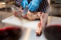 Chef cleans raw leg of lamb