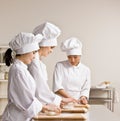 Chef co-workers whites kneading dough in kitchen Royalty Free Stock Photo
