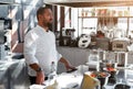 The chef conducts a master class in cooking. On the background is kitchen utensils, on the table in front of him vegetables in Royalty Free Stock Photo