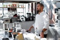 The chef conducts a master class in cooking. On the background is kitchen utensils, on the table in front of him vegetables in Royalty Free Stock Photo