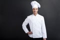Chef cook against dark background smiling with hat holdinf spoon Royalty Free Stock Photo