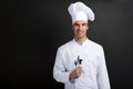 Chef cook against dark background smiling with hat holdinf spoon Royalty Free Stock Photo