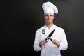 Chef cook against dark background smiling with hat holdinf spoon Royalty Free Stock Photo