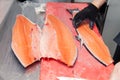 Closeup whole fresh salmon fish preparing fillet with knife on red cutting board in professional kitchen of restaurant. Concept Royalty Free Stock Photo