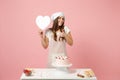 Chef cook confectioner or baker in apron white t-shirt, toque chefs hat cooking cake or cupcake at table hold like heart