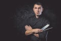 Chef cook holds a knife over dark grey background