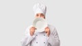 Cook Man Holding Plate Near Face Standing, White Background Royalty Free Stock Photo