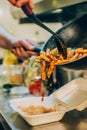 Chef cook pours spaghetti into fast food plastic delivery pack Royalty Free Stock Photo