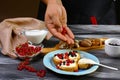 Chef cook sprinkles sweet berries to crostini sandwiches with cream cheese ricotta, blueberries and honey on the whole grain bread Royalty Free Stock Photo