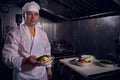 Chef cook in a white apron and cooks hat on a kitchen doing his lovely job Royalty Free Stock Photo