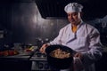 Chef cook in a white apron and cooks hat on a kitchen Royalty Free Stock Photo