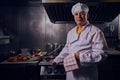 Chef cook in a white apron and cooks hat on a kitchen Royalty Free Stock Photo