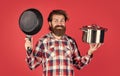 chef cooking dinner. mature guy in checkered shirt with pan. stylish male going to cook food. bearded man with moustache