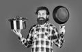 chef cooking dinner. mature guy in checkered shirt with pan. stylish male going to cook food. bearded man with moustache